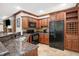 Basement kitchen with granite countertops, wood cabinets, and black appliances at 2110 Cheviot Ct, Greenwood, IN 46143