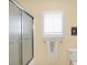 Bathroom featuring glass shower door, window with white shutters, and humorous decor at 2110 Cheviot Ct, Greenwood, IN 46143