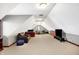 A finished bonus room with an angled ceiling features a seating area and a drumset at 2110 Cheviot Ct, Greenwood, IN 46143