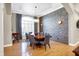 Stunning dining room with a brick accent wall, a long table, and light-filled windows covered with shutters at 2110 Cheviot Ct, Greenwood, IN 46143