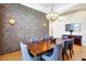 Contemporary dining area showcasing a stone wall, a wooden table, and stylish upholstered chairs at 2110 Cheviot Ct, Greenwood, IN 46143