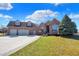 Beautiful brick home with a three-car garage, well-manicured lawn, and mature landscaping under a sunny sky at 2110 Cheviot Ct, Greenwood, IN 46143