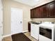 Bright laundry room features modern washer and dryer units, storage cabinets and utility sink at 2110 Cheviot Ct, Greenwood, IN 46143