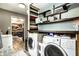Laundry room with modern appliances, open shelving, and wood-look flooring near kitchen space at 2758 S Lyons Ave, Indianapolis, IN 46241