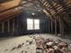 Spacious attic reveals exposed rafters, a window view, and scattered brick debris, a renovation project at 2822 Mcpherson St, Indianapolis, IN 46205