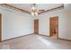 A large bedroom with multiple doors, neutral carpet, and ceiling fan at 2979 Colony Lake E Dr, Plainfield, IN 46168