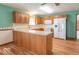 Kitchen featuring wooden cabinets, white appliances, laminate countertop and flooring, and retro wallpaper at 2979 Colony Lake E Dr, Plainfield, IN 46168