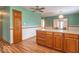 A spacious kitchen with wood cabinets, laminate floors, a center island, and retro-style wallpaper at 2979 Colony Lake E Dr, Plainfield, IN 46168