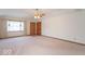 A spacious living room with neutral carpeting, a ceiling fan, and natural light filtering through the windows at 2979 Colony Lake E Dr, Plainfield, IN 46168