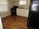 A kitchen with wood laminate flooring and white cabinets with a black gas range and a stainless steel sink at 3160 Graceland Ave, Indianapolis, IN 46208
