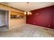 Dining room with red accent wall, light fixture, and connection to the kitchen at 4247 Larkspur Trce, Indianapolis, IN 46237