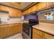 Traditional kitchen with wood cabinets, light countertops, and a black range at 4247 Larkspur Trce, Indianapolis, IN 46237