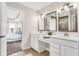 Bathroom featuring double vanities, mirrors, modern lighting, and an open view into the primary bedroom at 449 Hidden Hills Dr, Pittsboro, IN 46167