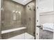 Modern shower with tile surround, glass door, a bench and view into bedroom at 449 Hidden Hills Dr, Pittsboro, IN 46167