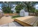 Large backyard with a wood deck, shed, grassy area, gravel and a wooden fence at 509 St Paul St, Indianapolis, IN 46203