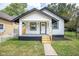 Charming home features a manicured lawn and inviting porch, with black and white trim at 509 St Paul St, Indianapolis, IN 46203