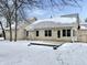 Rear exterior featuring a concrete patio, door and windows with a snow covered lawn at 5791 Station Hill Dr, Avon, IN 46123