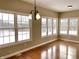 Dining room with gleaming hardwood floors, neutral paint, large windows and chandelier at 5791 Station Hill Dr, Avon, IN 46123