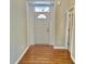A view of the entryway features hardwood floors and a white front door with decorative trim and transom window at 5791 Station Hill Dr, Avon, IN 46123