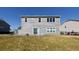 View of the back of the house with a concrete patio, sliding glass door, and a well-maintained lawn on a sunny day at 7139 Prelude Rd, Brownsburg, IN 46112