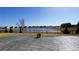 View from the stamped concrete patio overlooking a tranquil pond and neighborhood homes on a sunny day at 7139 Prelude Rd, Brownsburg, IN 46112