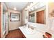 Bathroom with wood-trimmed sink and large mirror at 7808 Crossgate Ln, Southport, IN 46227