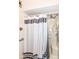 A well-maintained bathroom featuring a gray and white shower curtain at 7808 Crossgate Ln, Southport, IN 46227