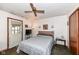 A well-lit bedroom featuring a ceiling fan, comfortable bed, and white door with covered window at 7808 Crossgate Ln, Southport, IN 46227
