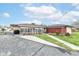 The exterior of this home features a long screened-in patio, an outbuilding, and mature trees at 7808 Crossgate Ln, Southport, IN 46227