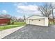 Detached one-car garage featuring paneled garage door, side entrance, and dark pavement driveway with lawn at 7808 Crossgate Ln, Southport, IN 46227