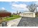 Detached one-car garage featuring paneled garage door, side entrance, and dark pavement driveway with lawn at 7808 Crossgate Ln, Southport, IN 46227