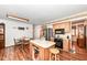 Eat-in kitchen featuring wooden cabinets, stainless steel appliances, a center island and wood flooring at 7808 Crossgate Ln, Southport, IN 46227
