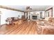 Spacious living room featuring a brick fireplace, ceiling fan, and wood flooring at 7808 Crossgate Ln, Southport, IN 46227