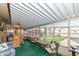 Sunroom with green carpet, vintage furnishings, white blinds and aluminum framed ceiling panels at 7808 Crossgate Ln, Southport, IN 46227