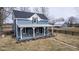 Classic two-story home with a covered porch, complemented by a barn, set in a pastoral landscape at 7968 E 200 S, Whitestown, IN 46075