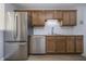 Kitchen featuring stainless steel appliances, wooden cabinetry, and white tile backsplash at 9652 Highgate N Cir, Indianapolis, IN 46250