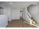 Living area featuring wood floors, stairs leading to the upper level, and access to other rooms at 9652 Highgate N Cir, Indianapolis, IN 46250