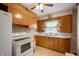 Efficient kitchen with wooden cabinetry and white appliances, designed for easy meal preparation at 9841 E Raymond St, Indianapolis, IN 46239