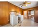 Functional laundry room with white appliances, wood-paneled walls, and plenty of natural light at 9841 E Raymond St, Indianapolis, IN 46239