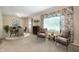 Inviting living area with seating, dining table and a large window with patterned drapery, offering a relaxing space at 9841 E Raymond St, Indianapolis, IN 46239