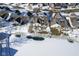 Aerial view shows home's backyard with pond, patio and surrounding neighborhood covered in snow in winter at 10953 Mount Vernon N Trl, Indianapolis, IN 46229
