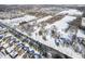 Wide aerial view of surrounding neighborhood showing the street, surrounding business area and snow covered landscape at 10953 Mount Vernon N Trl, Indianapolis, IN 46229