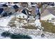 Backyard aerial view of home featuring a patio, snowy landscape and pond with rock features in winter at 10953 Mount Vernon N Trl, Indianapolis, IN 46229