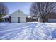 Inviting home featuring a two-car garage, brick accents, and snowy front yard at 10953 Mount Vernon N Trl, Indianapolis, IN 46229