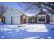 Charming home featuring a two-car garage and brick accents, set against a snowy landscape at 10953 Mount Vernon N Trl, Indianapolis, IN 46229