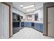 Well-lit kitchen featuring white tile floors, blue cabinets, and black appliances at 10953 Mount Vernon N Trl, Indianapolis, IN 46229