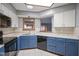 Bright kitchen featuring blue cabinets, white countertops, and modern appliances, with a skylight at 10953 Mount Vernon N Trl, Indianapolis, IN 46229