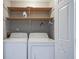Laundry room with a washer, dryer, and wood shelving at 10953 Mount Vernon N Trl, Indianapolis, IN 46229