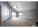 Open-concept living room with vaulted ceilings, large windows, and neutral carpet at 10953 Mount Vernon N Trl, Indianapolis, IN 46229
