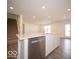 Kitchen island view, showcasing sink, cabinetry, stainless dishwasher with stairs and doorway nearby at 11322 N Quillow Way, Monrovia, IN 46157